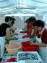 Volontari all'opera nel preparare il pesce (28/6/2013)