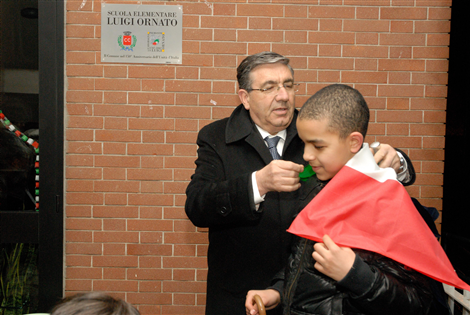 Il Consigliere Negro avvolge il tricolore sulle spalle di un bambino